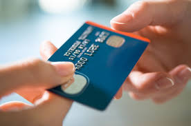 Carte bancaire posée sur un reçu de paiement en devise étrangère et un terminal de paiement