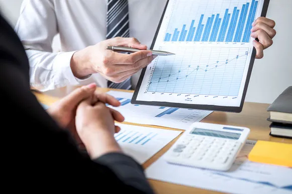 Dirigeants d'une PME examinant un dossier de financement pour une filiale à l'étranger