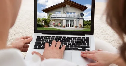 Dossier de financement immobilier avec plan de maison, clés et contrat de prêt libellé en devise étrangère
